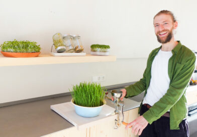Gesundheitsberater Tobias Fromligt in einer Küche mit verschiedenen Pflanzensprossen