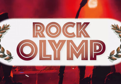 Der Schriftzug Rock Olymp auf einem unscharfen Foto von einem Rockkonzert