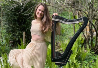 Die Harfenistin Annalena Storch mit ihrem Instrument in einem Park