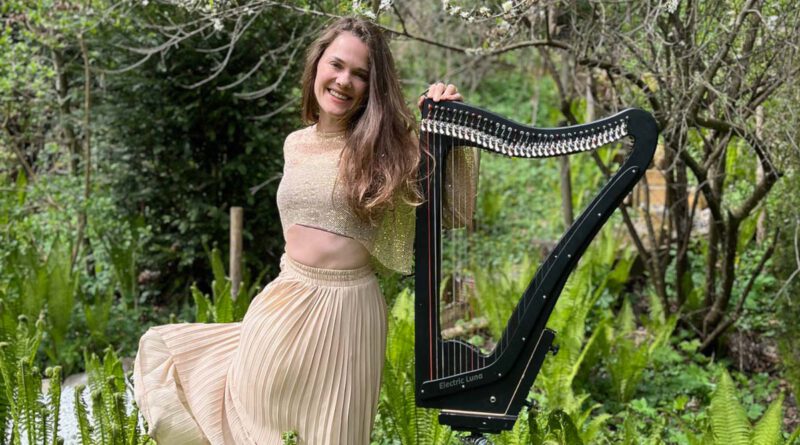 Die Harfenistin Annalena Storch mit ihrem Instrument in einem Park