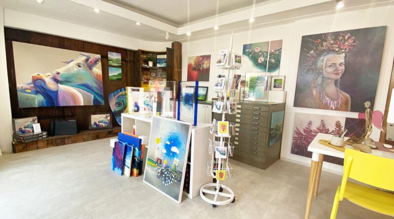 Blick in eine Künstleratelier mit vielen Bildern an den Wänden