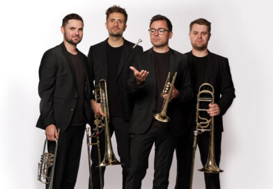 Die Ensemblemitglieder von TetraBass in schwarzen Anzügen mit ihren Blechblasinstrumenten