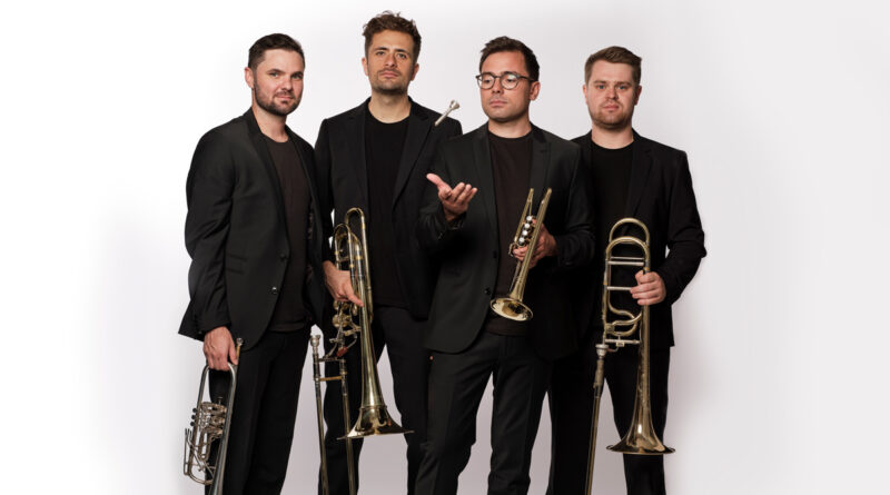 Die Ensemblemitglieder von TetraBass in schwarzen Anzügen mit ihren Blechblasinstrumenten