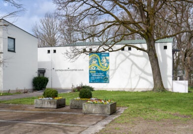Bayernausstellung 2025 „Projekt Freiheit – Memmingen 1525“ geht zu Ende Ein weißes Gebäude im Park mit einem großen Ausstellungsbanner an der Außenwand
