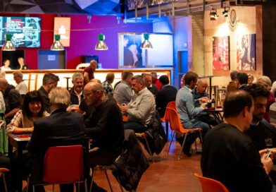 Erfolgreiche Charity-Schafkopf-Premiere Menschen sitzen in einem großen Saal in Gruppen an Tischen zum Kartenspielen