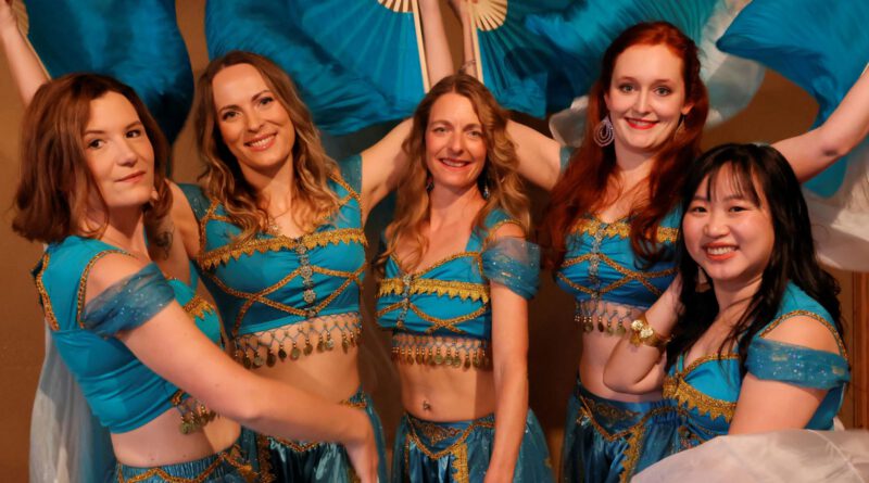 Frauen in Bauchtanzkostümen mit Fächern und Schleiern