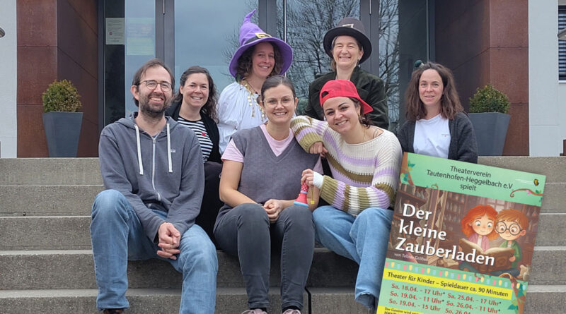 Mitglieder des Theatervereins sitzen zum Teil mit lustigen Hüten auf einer Treppe