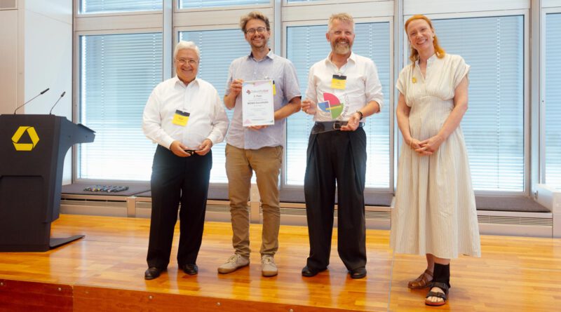 MEWO Kunsthalle erhält ZukunftsGut-Preis der Commerzbank-Stiftung vier Personen stehen auf einer kleinen Bühne und halten lächelnd Preise und Urkunden in die Kamera